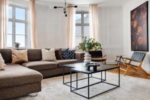 Sanders Square - Spacious Six-Bedroom Apartment Near Amalienborg في كوبنهاغن: غرفة معيشة مع أريكة وطاولة قهوة