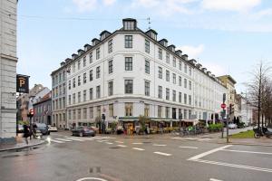 a large white building on the corner of a street at Sanders Square - Spacious Six-Bedroom Apartment Near Amalienborg in Copenhagen