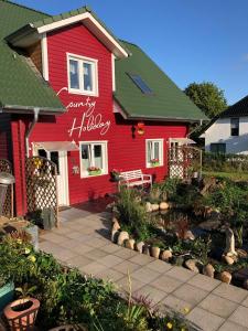 ein rotes Haus mit einem Garten davor in der Unterkunft Country Heaven in Grömitz