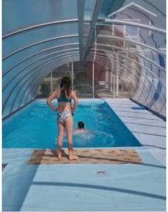 Eine Frau im Bikini steht neben einem Pool. in der Unterkunft Country Heaven in Grömitz