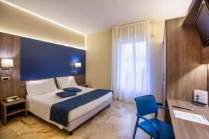 Pokój hotelowy z łóżkiem i niebieską ścianą w obiekcie Hotel Mediterranée w mieście Spotorno