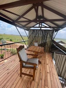 una terrazza in legno con tavolo e sedie sul tetto di Motubane Guest Farm a Madeteleli