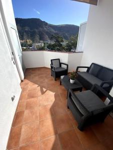 莫甘海灘的住宿－VV VELERO，阳台配有椅子、沙发和桌子