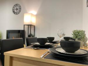 una mesa con platos negros y copas de vino. en Luxurious New 2 Bed Apartment in Burnley, Lancashire, en Burnley