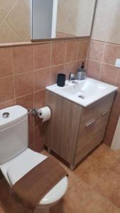 a bathroom with a white toilet and a sink at VV VELERO in Puerto de Mogán