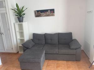 a living room with a gray couch and a ottoman at VV VELERO in Puerto de Mogán