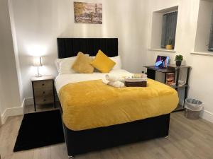 a bedroom with a bed with a yellow blanket at Luxurious New 2 Bed Apartment in Burnley, Lancashire in Burnley