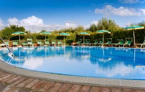 ein großer Pool mit Stühlen und Sonnenschirmen in der Unterkunft Agriturismo La Fattoria in Ascea