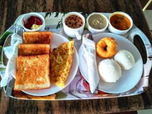 a tray of breakfast foods on a table at Hotel Adore Palace - Near Mumbai Airport & Visa Consulate in Mumbai