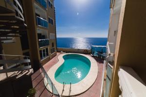 uma vista para uma piscina a partir da varanda de um edifício em Maspalomas,Flipper em Maspalomas