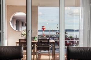 a dining room with a table and a view of a harbor at Apartmenthaus Hafenspitze Ap 5 - "am Yachthafen 5" - Blickrichtung offenes MeerStrandpromenade - a72320 in Eckernförde