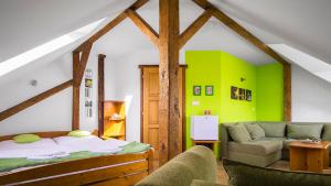 a bedroom with green walls and a bed and a couch at penzion Horácko in Unčín