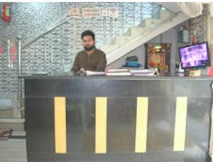 a man standing at a counter in a store at Hotel Kanha Dham, Kanpur in Kānpur