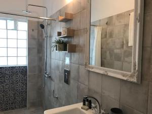 a bathroom with a sink and a shower with a mirror at Katoi House - Central Skyros Village in Skiros