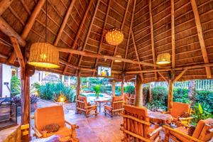 a large wooden pavilion with chairs and a table at 2 Friends Beach Hotel in Entebbe