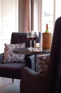 una mesa con dos copas de vino y una silla en B&B Roodbeekerhof, en Vlodrop
