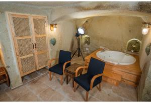 a bathroom with a sink and two chairs and a table at Bala Cave House in Avanos