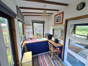 una cocina en una cabaña con barra y fregadero en Countryside Garden Summer House en Calne