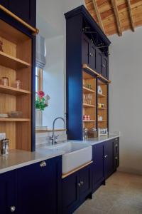 a kitchen with blue cabinets and a white sink at The Studio in Castle Bytham