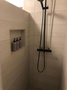 a shower with a shower head in a bathroom at Bessastaðir Guesthouse in Hvammstangi