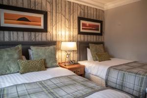 una camera d'albergo con due letti e una lampada di Riverside Lodge Hotel a Irvine