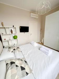 a bedroom with two white beds and a tv at Casa Nanà in Florence