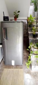 a metal refrigerator in a room with potted plants at Mandara Rest in Hikkaduwa