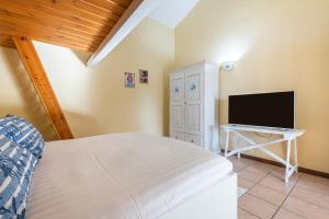 1 dormitorio con 1 cama y TV de pantalla plana en Villa Sureu, en Solanas
