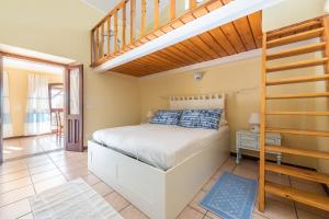 1 dormitorio con 1 cama y escalera de madera en Villa Sureu, en Solanas