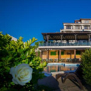 a building with a swimming pool in front of a building at Family Hotel Sunrise in Lozenets