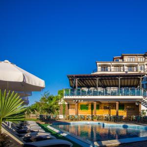 a hotel with a swimming pool and a building at Family Hotel Sunrise in Lozenets