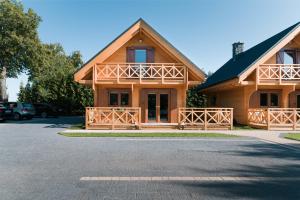 a large wooden house with a parking lot at ,,Morski Zakątek'' Domki całoroczne in Ustronie Morskie