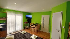 a green room with a table and a dining room at STOP&RELAX Apartment in Liptovská Osada