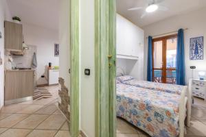 Cet appartement comprend une chambre avec un lit et une chambre avec une cuisine. dans l'établissement Bellarosa 3, à Villasimius