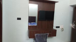 um quarto com um espelho e uma televisão num quarto em Tru Comfort em Pondicherry