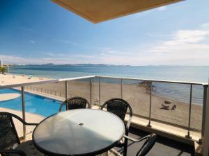 d'une table et de chaises sur un balcon avec vue sur la plage. dans l'établissement La Manga Beach Club Frontal, à La Manga del Mar Meno
