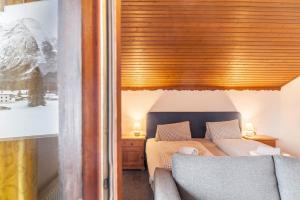 een slaapkamer met een bed en een houten plafond bij Fewo 5 Haus am Lärchenhang in Leutasch