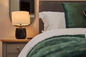 um quarto com uma cama e um candeeiro numa mesa de cabeceira em The Swan Apartment - Free parking em Harrogate