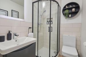 a bathroom with a shower and a sink and a toilet at The Swan Apartment - Free parking in Harrogate