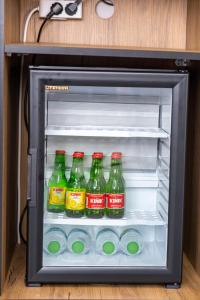 an open refrigerator filled with bottles of soda at Comfort Center Suit Hotel in Edirne