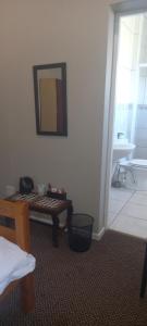 a room with a table and a mirror and a bathroom at The Kraal Addo in Addo