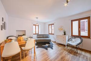 un soggiorno con divano, tavolo e sedie di Casa Elvezia - Happy Rentals a Piandera