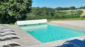 uma piscina com banco e cadeiras em Zenbreak Villa La Hourniere Sainte Marie de Gosse no01 em Port-de-Lannes