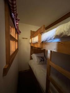 sypialnia z dwoma łóżkami piętrowymi i oknem w obiekcie Arc 1950 - Auberge Jérôme - 4 à 6p - 1 chambre et 1 coin montagne séparé w mieście Arc 1950 +11 zdjęć