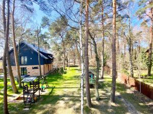 a cabin in the woods with a picnic table and trees at Apartament Poezja Ciszy in Dębki