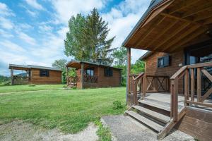 a log cabin with a porch and stairs to a house at Camping Au pays de Hanau in Dossenheim-sur-Zinsel