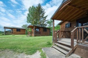 eine Blockhütte mit einer Veranda und einer Treppe zu einem Haus in der Unterkunft Camping Au pays de Hanau in Dossenheim-sur-Zinsel