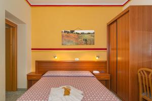 1 dormitorio con 1 cama y una pintura en la pared en Hotel Dolly, en Viareggio