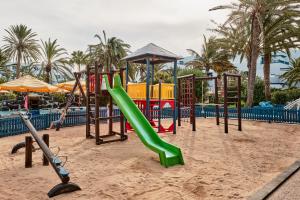 a playground with a green slide in the sand at Seaside Los Jameos in Puerto del Carmen