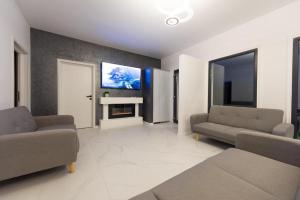 ein Wohnzimmer mit zwei Sofas und einem Fernseher in der Unterkunft Moon House in Cluj-Napoca
